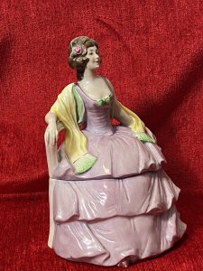 A Fashionable Elaborate Three Tiered Crinoline Gown With Bustier Bodice Decorated With Central Green Bow And Vibrant Yellow Scarf Placed Over Arms. Charming Details With Small Pointed Shoe Poking Out From Under The Gown.