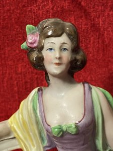 A Fashionable Elaborate Three Tiered Crinoline Gown With Bustier Bodice Decorated With Central Green Bow And Vibrant Yellow Scarf Placed Over Arms. Charming Details With Small Pointed Shoe Poking Out From Under The Gown.