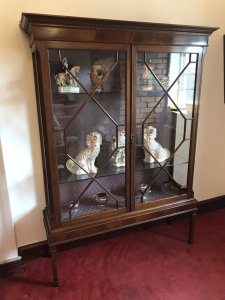 Tall Antique Georgian Chippendale Style Display Cabinet With Chamfered Legs Two Astroglazed Doors With Diamond Shaped Pains With Two Glass Shelves With Delicate Purple Fabric Interior. Beautiful Hand Crafted Cabinet In Solid Mahogany Sits Upon Stunning Tall Chamfered Legs Elegant And Useful For Display Of Fine China And Trinkets With Original Key Condition- Stunning Antique Dimensions In Inches Height 72” Width 53” Depth 16”