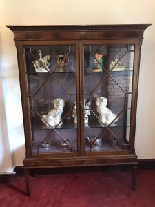 Tall Antique Georgian Chippendale Style Display Cabinet With Chamfered Legs Two Astroglazed Doors With Diamond Shaped Pains With Two Glass Shelves With Delicate Purple Fabric Interior. Beautiful Hand Crafted Cabinet In Solid Mahogany Sits Upon Stunning Tall Chamfered Legs Elegant And Useful For Display Of Fine China And Trinkets With Original Key Condition- Stunning Antique Dimensions In Inches Height 72” Width 53” Depth 16”