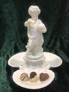 Putti Standing On Pile Of Books With A Globe In Hand, In The Form Of A Water Fountain. Masked Heads In Oyster Shell Shaped Trio Of Dishes For Fruits/ BonBons Or Canapés. Table Centre Piece Fruit Comport/ Statue.