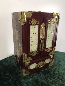 Vintage Oriental Brass Bound Jade Panelled Jewellrey Casket Beautiful Casket With Two Doors Revealing Three Internal Shelves And Opening Bottom Drawer Front And Two Side Panels Have Fine Shaped Jade Carved Insets With Ornate Brass Engraving Ornate Brass Carry Handle On The Top Shaped Feet Very Ornate Unusual Casket Perfect For Jewels, Documents Or Trinkets Made From Hardwood With Quality Workmanship Circa - 1950’s Origin - China Dimensions In Inches Height 11” Width 7 1/4” Depth 5.5” Weight Approx 10kg
