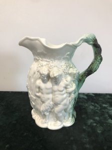 Classical Antique Greek Mythology Rare Coleport Water Jug Front Side~ Two Centaurs Leading Away A Man The Handle Is A Grape Vine With Dark Green Lustre Glaze The Reverse Side ~ Is A Cherub Riding An Oxen Guided By A Wise Man Made In Creme Hand Paste Porcelain Stunning Mythological Piece Circa 1840 Colouring - White In Perfect Condition Collectors Item Dimensions In Inches Height Width