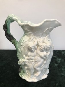 Classical Antique Greek Mythology Rare Coleport Water Jug Front Side~ Two Centaurs Leading Away A Man The Handle Is A Grape Vine With Dark Green Lustre Glaze The Reverse Side ~ Is A Cherub Riding An Oxen Guided By A Wise Man Made In Creme Hand Paste Porcelain Stunning Mythological Piece Circa 1840 Colouring - White In Perfect Condition Collectors Item Dimensions In Inches Height Width