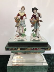 Pair Of 18th Century Style Chelsea Figurines Lady And A Gentleman Gathering Fruit And Game Standing On Shaped Gilded Plinths Painted In Bright Hues The Detail On These Figurines Is Breathtaking Chelsea Markings On The Bases Slight Damage On The Gentleman’s Forefinger Provenance Purchased From The Lord Hill Museum Shropshire Dimensions In Inches Height 7 1/4” Base 3” Square