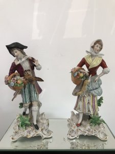 Pair Of 18th Century Style Chelsea Figurines Lady And A Gentleman Gathering Fruit And Game Standing On Shaped Gilded Plinths Painted In Bright Hues The Detail On These Figurines Is Breathtaking Chelsea Markings On The Bases Slight Damage On The Gentleman’s Forefinger Provenance Purchased From The Lord Hill Museum Shropshire Dimensions In Inches Height 7 1/4” Base 3” Square