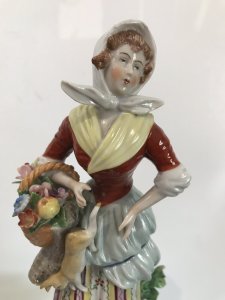 Pair Of 18th Century Style Chelsea Figurines Lady And A Gentleman Gathering Fruit And Game Standing On Shaped Gilded Plinths Painted In Bright Hues The Detail On These Figurines Is Breathtaking Chelsea Markings On The Bases Slight Damage On The Gentleman’s Forefinger Provenance Purchased From The Lord Hill Museum Shropshire Dimensions In Inches Height 7 1/4” Base 3” Square