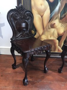 Fine Pair Regency Style Carved Elm Hall Seats Ornate Acanthus Leaf Carvings On Backs And Sides Cabriole Legs With Stunning Claw And Ball Feet Heavy Quality Antique Reproductions Intricate Carvings All Around Highly Polished Patina Craftsman Made Dimensions In Inches Height 37” Width 16” Depth 19.5”