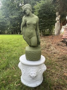 Set Upon Circular Plinth Base With Lion Head Decoration. Circular Plinth Height 31cm X Circumference 32cm. Statue Height 51cm X Width 23cm X Depth 18cm at base.